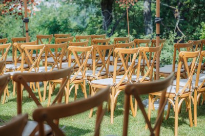 Main d'une personne tenant légèrement une robe blanche, avec un bracelet fin et une bague visible.