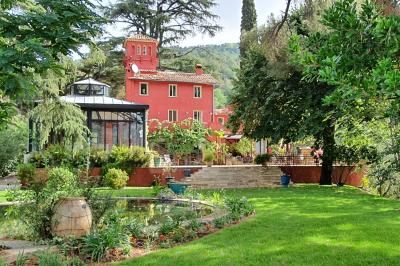 Main d'une personne tenant légèrement une robe blanche, avec un bracelet fin et une bague visible.