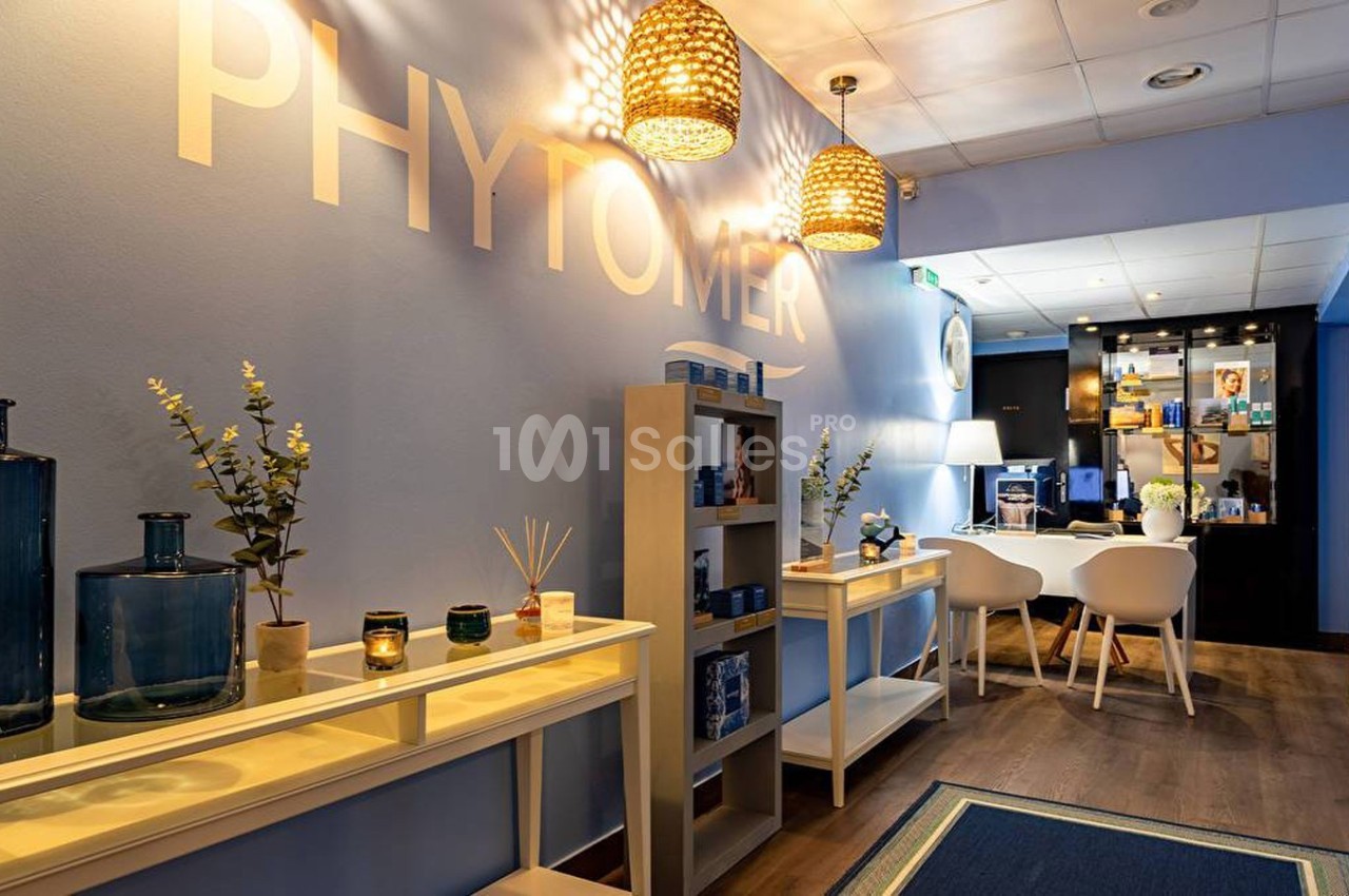 Intérieur d'un espace bien-être avec étagères, produits de soin, éclairage chaleureux et mobilier moderne.