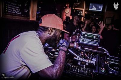 Miniature DJ Orgeval (Yvelines) - DJ Velrich #10 Un DJ mixe en plein air devant une foule, avec l'Arche de la Défense en arrière-plan.