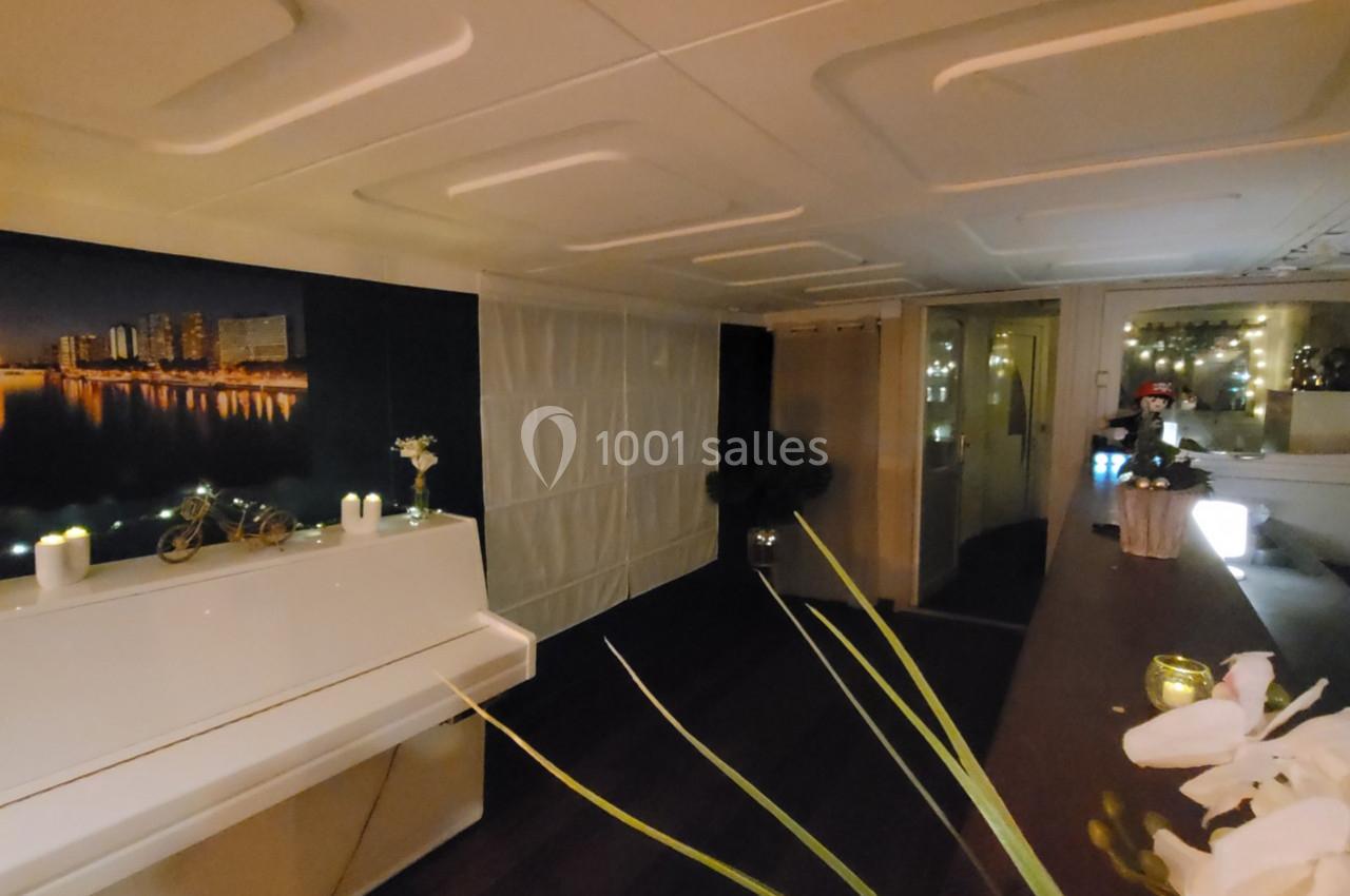 Intérieur chaleureux avec un piano blanc, des bougies allumées et une décoration moderne dans une ambiance tamisée.