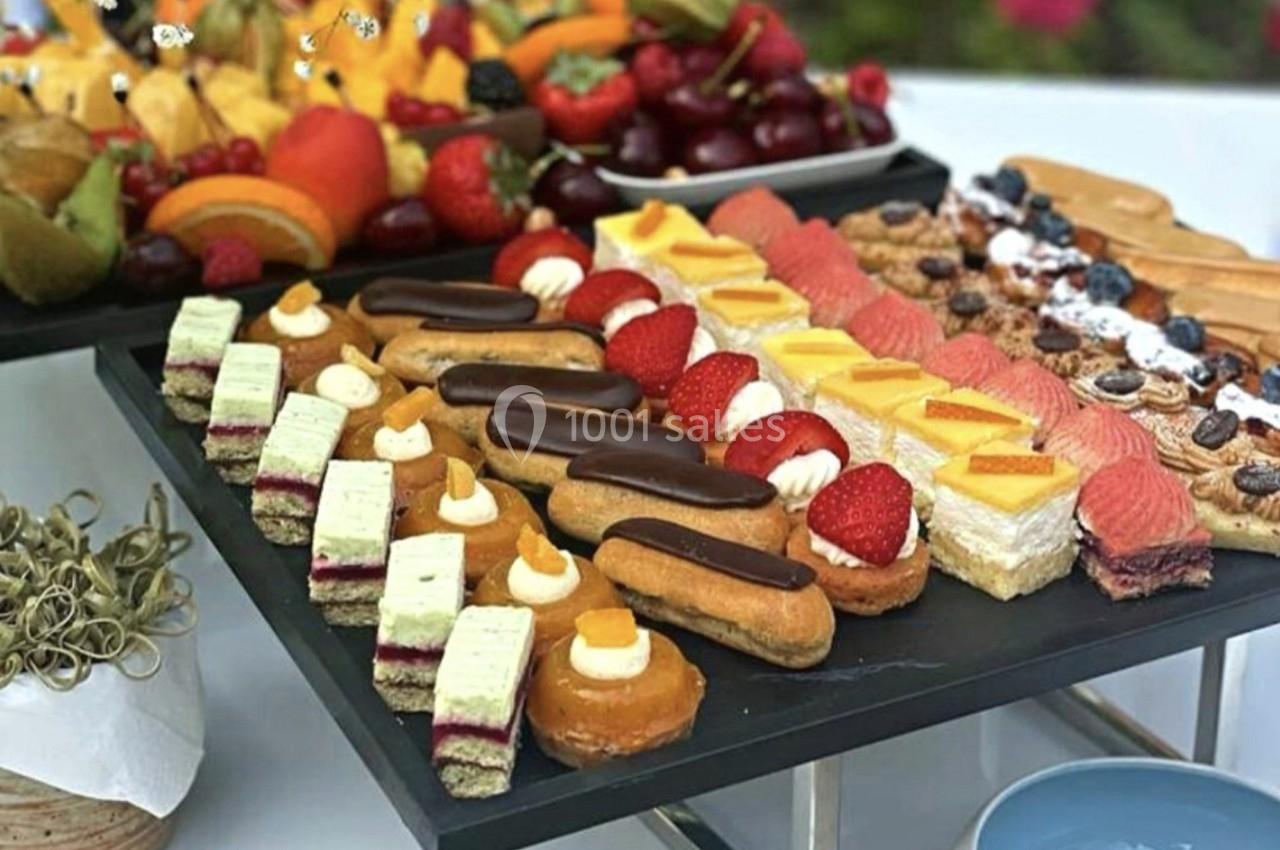 Plateau de pâtisseries variées comprenant éclairs, tartelettes aux fruits et gâteaux colorés, disposés sur une table.
