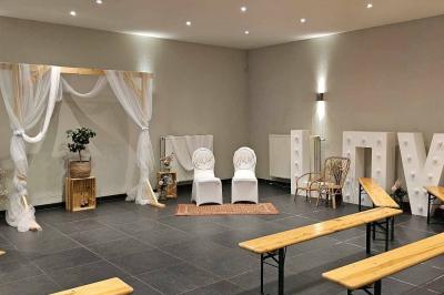 Salle vide avec de grandes baies vitrées donnant sur un espace extérieur verdoyant.