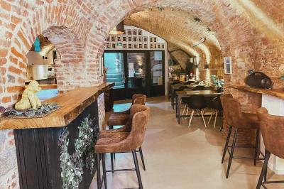 Miniature Location salle Arras (Pas-de-Calais) - Feel Good #3 Lavabo blanc avec miroir dans une pièce aux murs en pierre et éclairée par des lampes suspendues rondes.