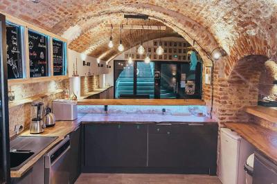 Miniature Location salle Arras (Pas-de-Calais) - Feel Good #2 Lavabo blanc avec miroir dans une pièce aux murs en pierre et éclairée par des lampes suspendues rondes.