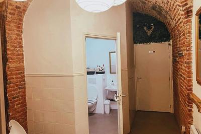 Miniature Location salle Arras (Pas-de-Calais) - Feel Good #12 Lavabo blanc avec miroir dans une pièce aux murs en pierre et éclairée par des lampes suspendues rondes.