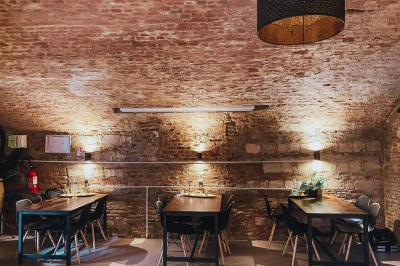 Miniature Location salle Arras (Pas-de-Calais) - Feel Good #6 Lavabo blanc avec miroir dans une pièce aux murs en pierre et éclairée par des lampes suspendues rondes.