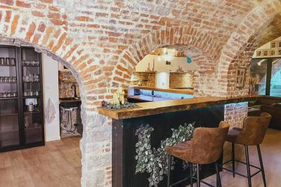 Miniature Location salle Arras (Pas-de-Calais) - Feel Good #7 Lavabo blanc avec miroir dans une pièce aux murs en pierre et éclairée par des lampes suspendues rondes.