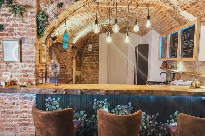 Miniature Location salle Arras (Pas-de-Calais) - Feel Good #9 Lavabo blanc avec miroir dans une pièce aux murs en pierre et éclairée par des lampes suspendues rondes.