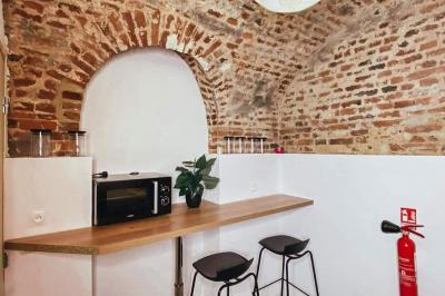 Miniature Location salle Arras (Pas-de-Calais) - Feel Good #11 Lavabo blanc avec miroir dans une pièce aux murs en pierre et éclairée par des lampes suspendues rondes.