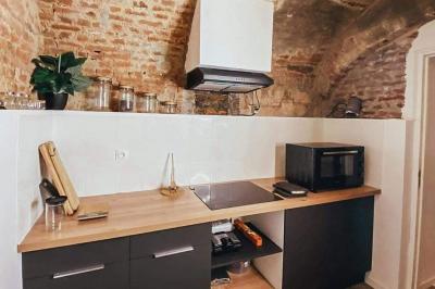 Miniature Location salle Arras (Pas-de-Calais) - Feel Good #10 Lavabo blanc avec miroir dans une pièce aux murs en pierre et éclairée par des lampes suspendues rondes.