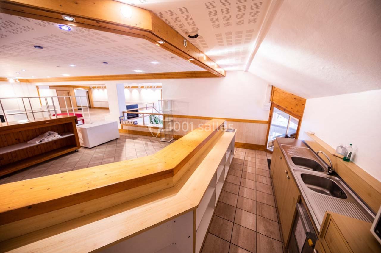 Cuisine ouverte avec un grand plan de travail en bois, double évier inox et vue sur un espace aménageable lumineux.