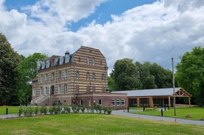 Des chèvres se tiennent près d'une clôture dans un champ herbeux entouré de barrières en bois.