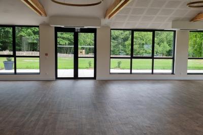 Des chèvres se tiennent près d'une clôture dans un champ herbeux entouré de barrières en bois.