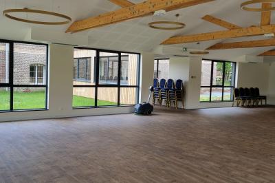 Des chèvres se tiennent près d'une clôture dans un champ herbeux entouré de barrières en bois.