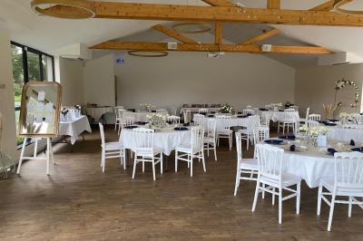 Des chèvres se tiennent près d'une clôture dans un champ herbeux entouré de barrières en bois.