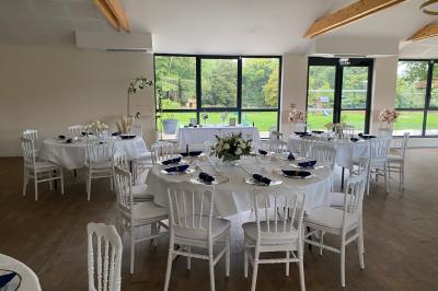 Des chèvres se tiennent près d'une clôture dans un champ herbeux entouré de barrières en bois.