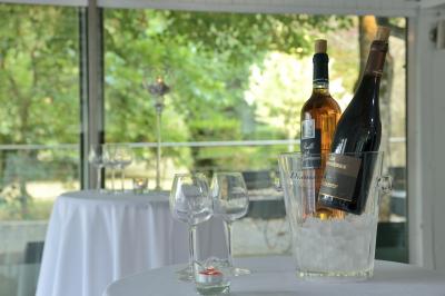 Allée pavée bordée d'arbres et de bâtiments en bois dans un cadre verdoyant sous un ciel dégagé.