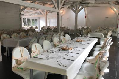 Allée pavée bordée d'arbres et de bâtiments en bois dans un cadre verdoyant sous un ciel dégagé.