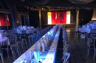 Allée pavée bordée d'arbres et de bâtiments en bois dans un cadre verdoyant sous un ciel dégagé.