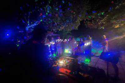 Miniature DJ Hyères (Var) - Prom'Art DJ Didou #4 Des artistes en costumes brillants dansent sur une scène illuminée par des projecteurs colorés et un écran lumineux.