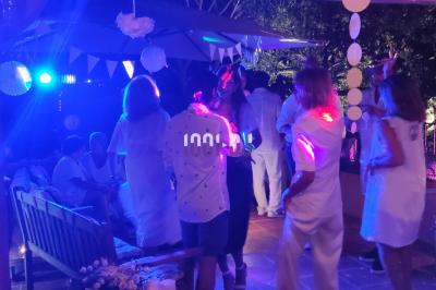 Des artistes en costumes brillants dansent sur une scène illuminée par des projecteurs colorés et un écran lumineux.