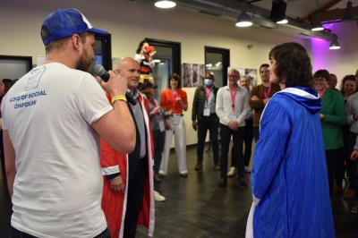 Une personne tient un jeu coloré avec une roue et des compartiments, marqué ’Le Social Bar’.