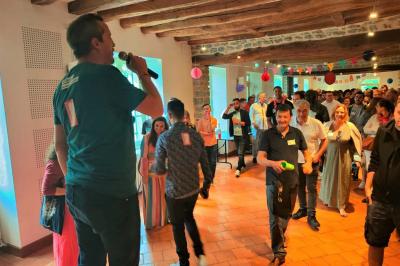 Une personne tient un jeu coloré avec une roue et des compartiments, marqué ’Le Social Bar’.