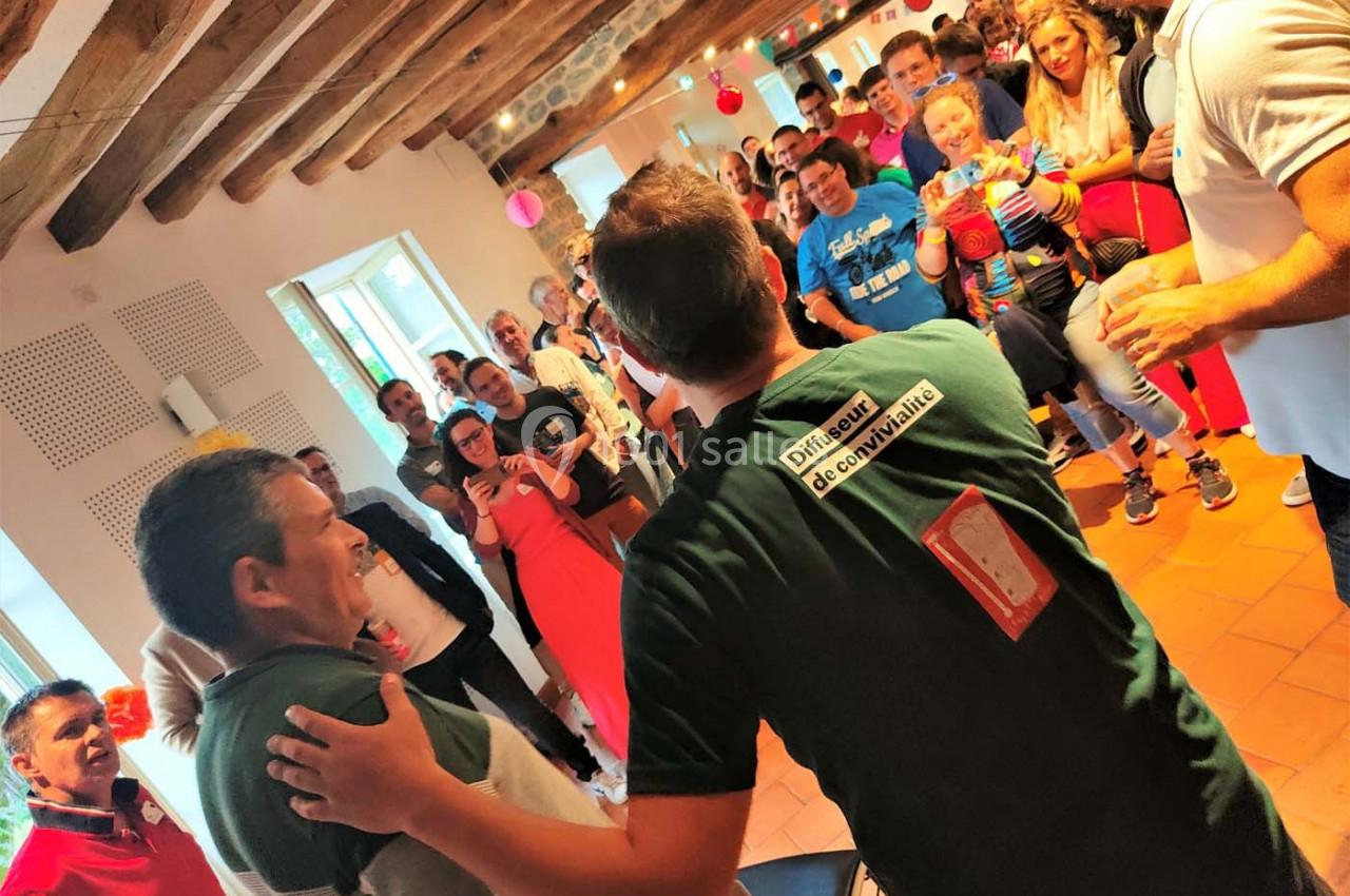 Un groupe de personnes rassemblées dans une salle, certaines souriantes et prenant des photos.