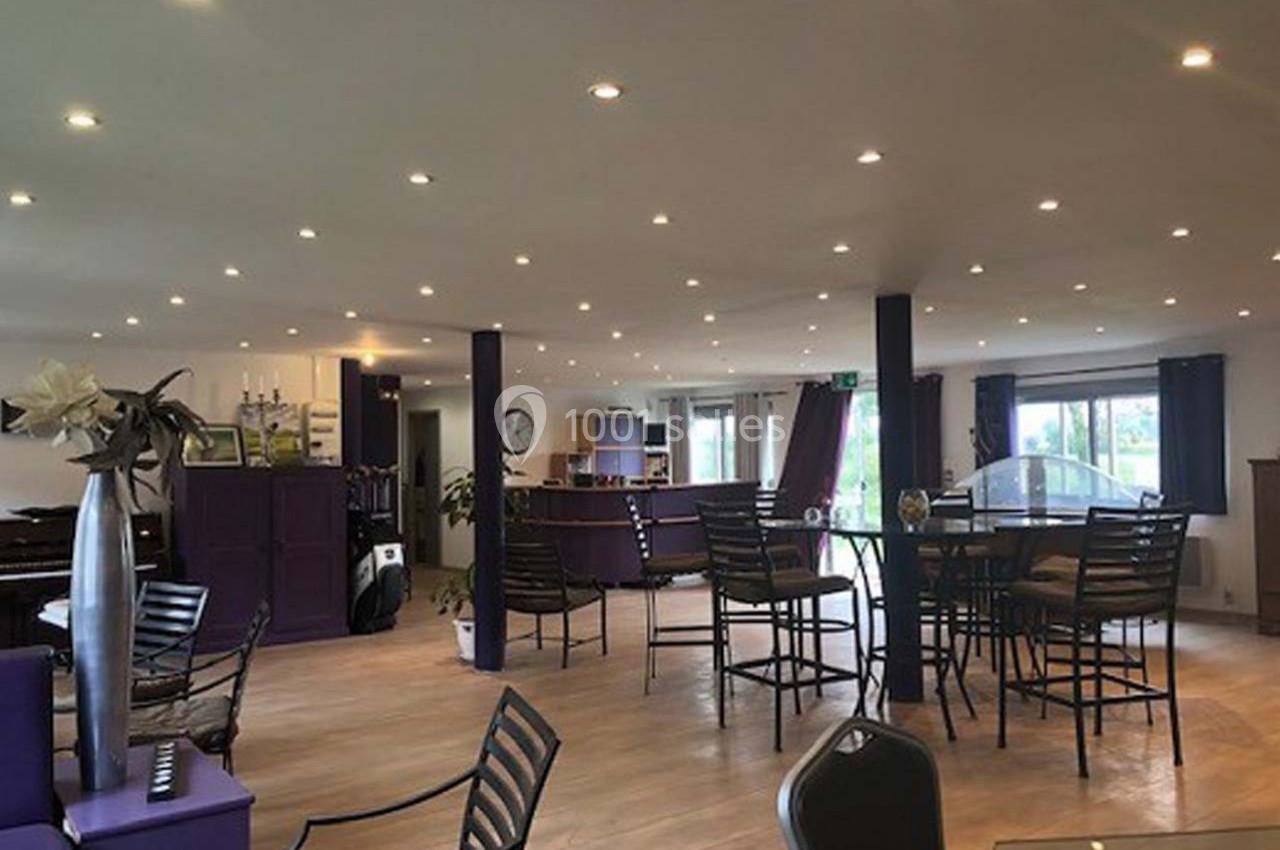 Location salle Hem (Nord) - O'Green du Château d'Hem #14 Salle lumineuse avec des tables et chaises en métal, décorée de tons violets et éclairée par des spots au plafond.