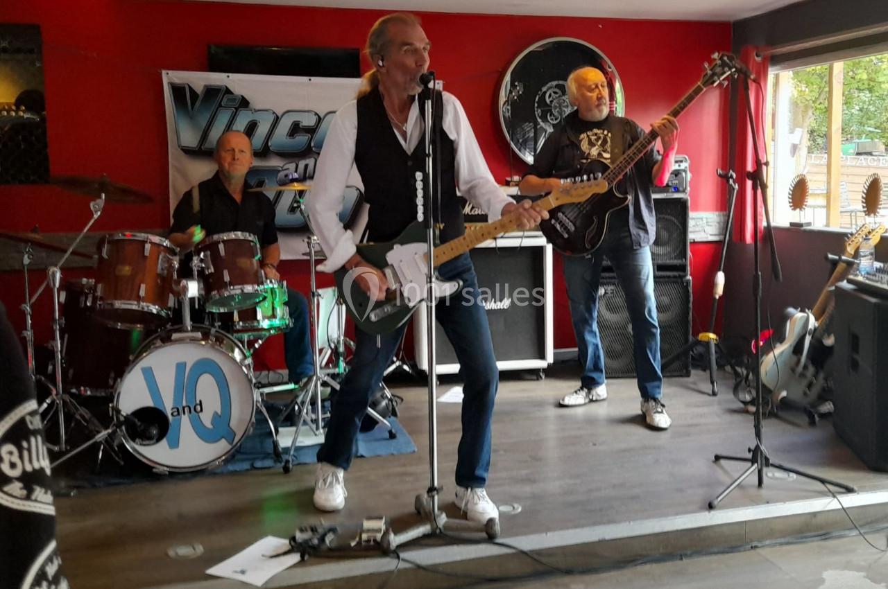 Location salle Hem (Nord) - O'Green du Château d'Hem #25 Un groupe de musiciens joue sur une petite scène dans un bar, avec batterie, guitare et basse.