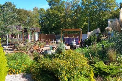 Miniature Location salle Hem (Nord) - O'Green du Château d'Hem #27 Table dressée en extérieur avec nappes blanches, fleurs en centre de table, parasols roses et verdure en arrière-plan.