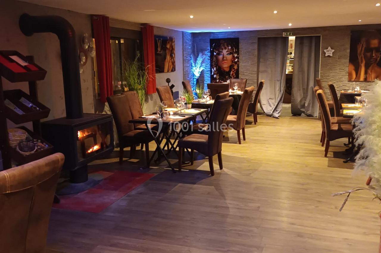 Location salle Hem (Nord) - O'Green du Château d'Hem #28 Salle de restaurant chaleureuse avec poêle à bois, tables dressées, décorations et éclairage tamisé.