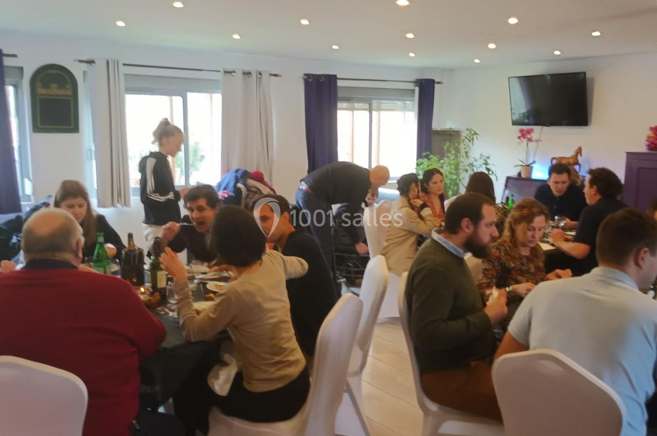 Location salle Hem (Nord) - O'Green du Château d'Hem #31 Des personnes assises autour de tables dans une salle lumineuse, partageant un repas convivial.