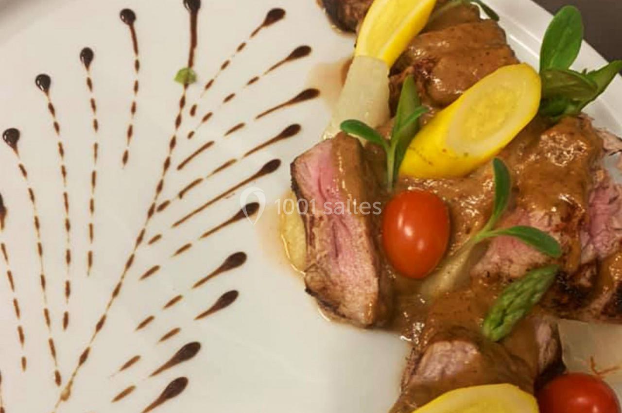 Location salle Hem (Nord) - O'Green du Château d'Hem #34 Assiette de viande grillée avec sauce, légumes colorés et décoration de sauce en éventail sur le côté.