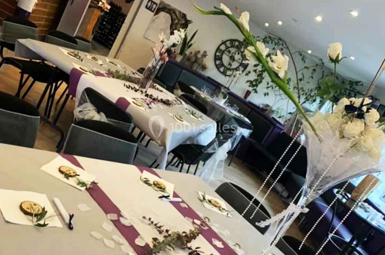 Location salle Hem (Nord) - O'Green du Château d'Hem #15 Salle décorée pour un événement avec tables dressées, nappes blanches, chemins de table violets et compositions florales.