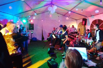 Miniature Location salle Hem (Nord) - O'Green du Château d'Hem #3 Table dressée en extérieur avec nappes blanches, fleurs en centre de table, parasols roses et verdure en arrière-plan.