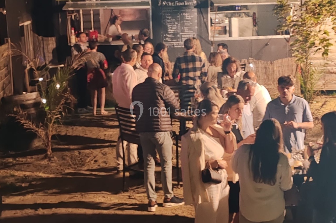 Location salle Hem (Nord) - O'Green du Château d'Hem #19 Groupe de personnes rassemblées en soirée devant un food truck éclairé, dans un cadre extérieur convivial.