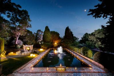 Miniature Location salle Mougins (Alpes-Maritimes) - Le Park Mougins #12 Jardin éclairé de nuit avec piscine, terrasse en pierre et bâtiments entourés de végétation.