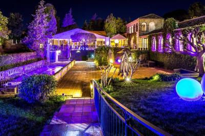 Miniature Location salle Mougins (Alpes-Maritimes) - Le Park Mougins #14 Jardin éclairé de nuit avec piscine, terrasse en pierre et bâtiments entourés de végétation.