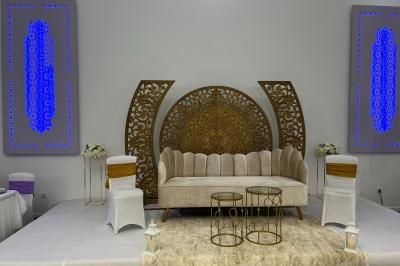 Miniature Location salle Herblay (Val-d'Oise) - Dream #18 Canapé beige avec décorations dorées, tables basses et chaises blanches dans une salle ornée de panneaux lumineux bleus.