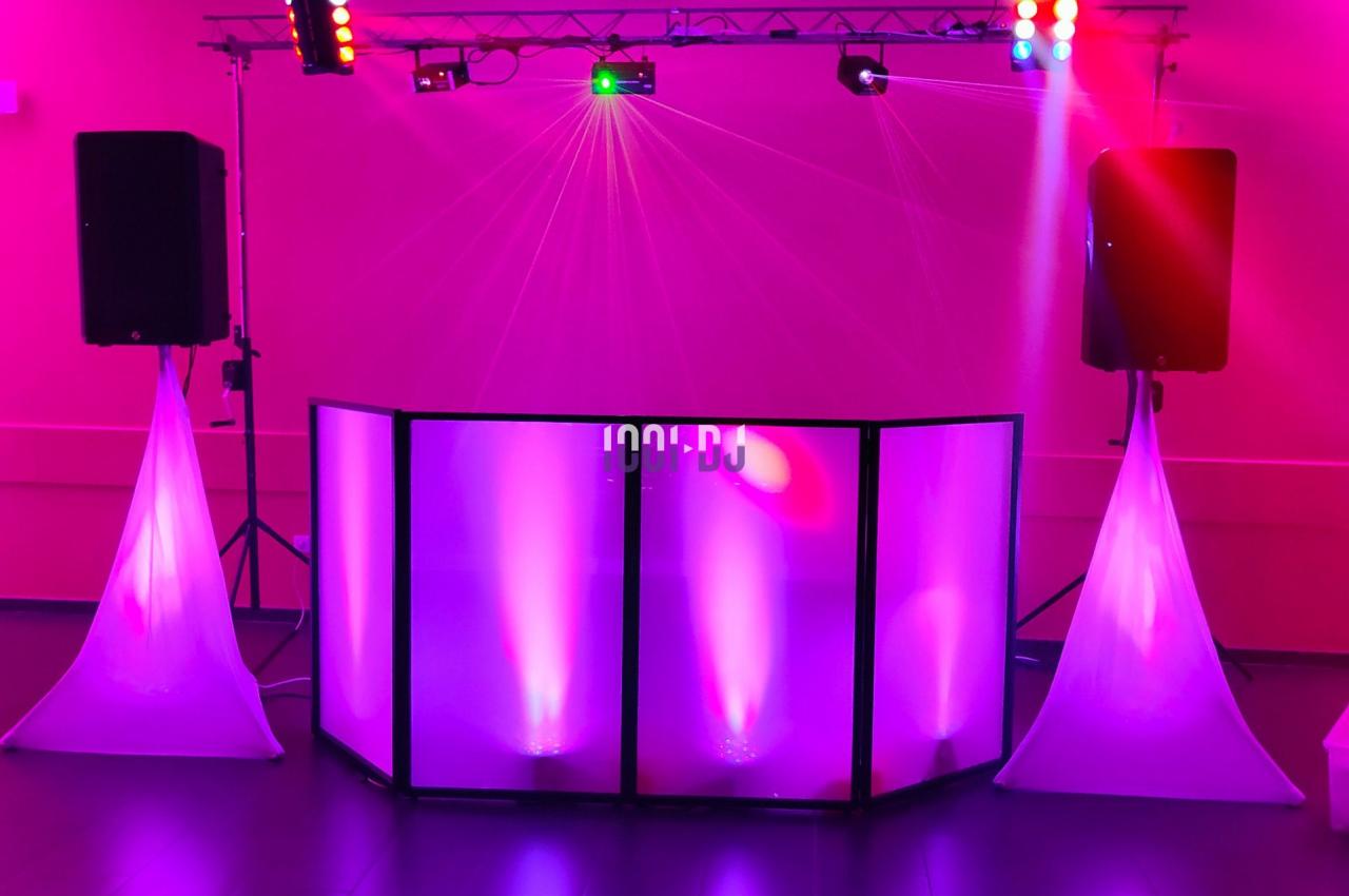 Équipement de sonorisation et éclairage lumineux rose installé dans une salle pour un événement festif.