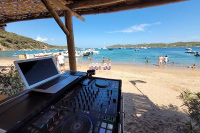 Des personnes assises à l'extérieur, regardant une présentation projetée sur un écran sous des guirlandes lumineuses.