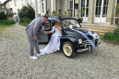 Miniature MARIES DEVANT LE CHATEAU Un marié aide sa partenaire en robe de mariée à sortir d'une voiture ancienne décorée pour un mariage.