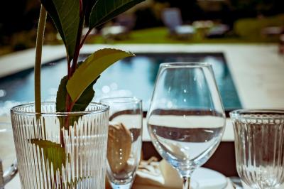 Miniature Traiteur Saint-Pardoux-Isaac (Lot-et-Garonne) - Lys d'Or #7 Centre de table floral avec roses blanches et feuillage, entouré de verres en cristal sur une table dressée en extérieur.