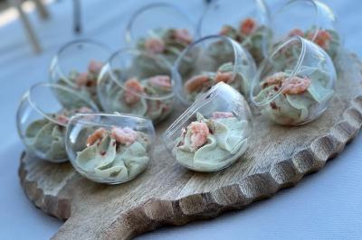 Miniature Traiteur Saint-Pardoux-Isaac (Lot-et-Garonne) - Lys d'Or #3 Centre de table floral avec roses blanches et feuillage, entouré de verres en cristal sur une table dressée en extérieur.