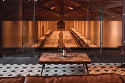 Vue aérienne d'un domaine viticole entouré de vignes, avec un plan d'eau visible à l'horizon.