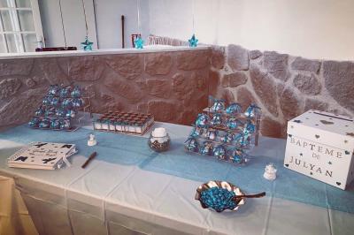 Salle spacieuse avec sol en parquet, murs en pierre et poutres blanches apparentes, éclairée par des lumières modernes.