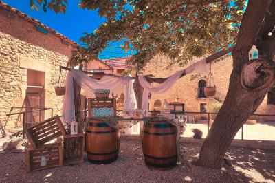 Décor de fête avec ballons beige et blanc, murs en pierre, présentoirs et un ours en peluche au centre.