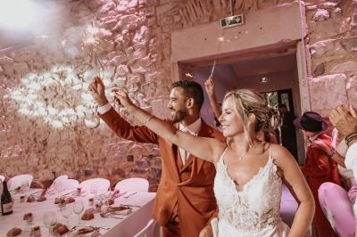 Décor de fête avec ballons beige et blanc, murs en pierre, présentoirs et un ours en peluche au centre.